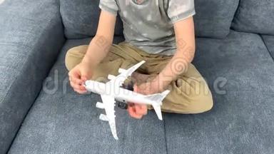 戴黑眼镜的孩子玩白色飞机玩具，飞行概念，旅行